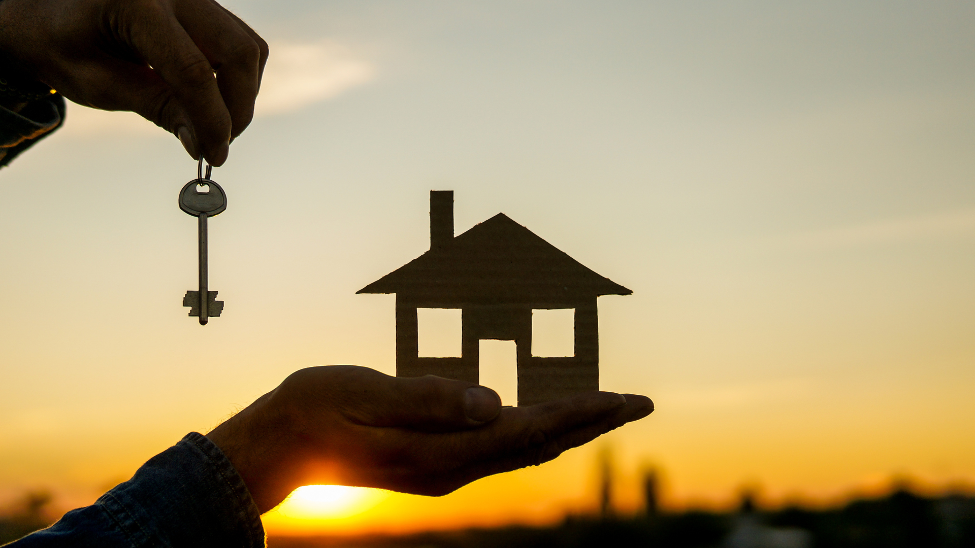 Buyer holding a house model and key, representing first-time homebuyer assistance