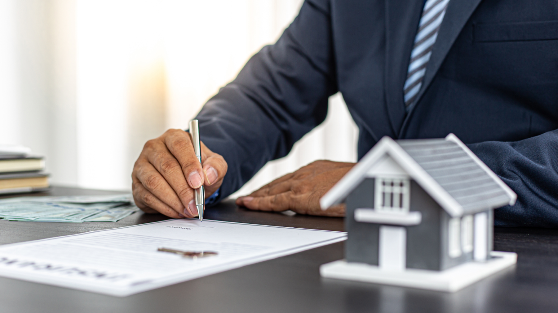 Mortgage document and model home representing how HOA dues affect buying power