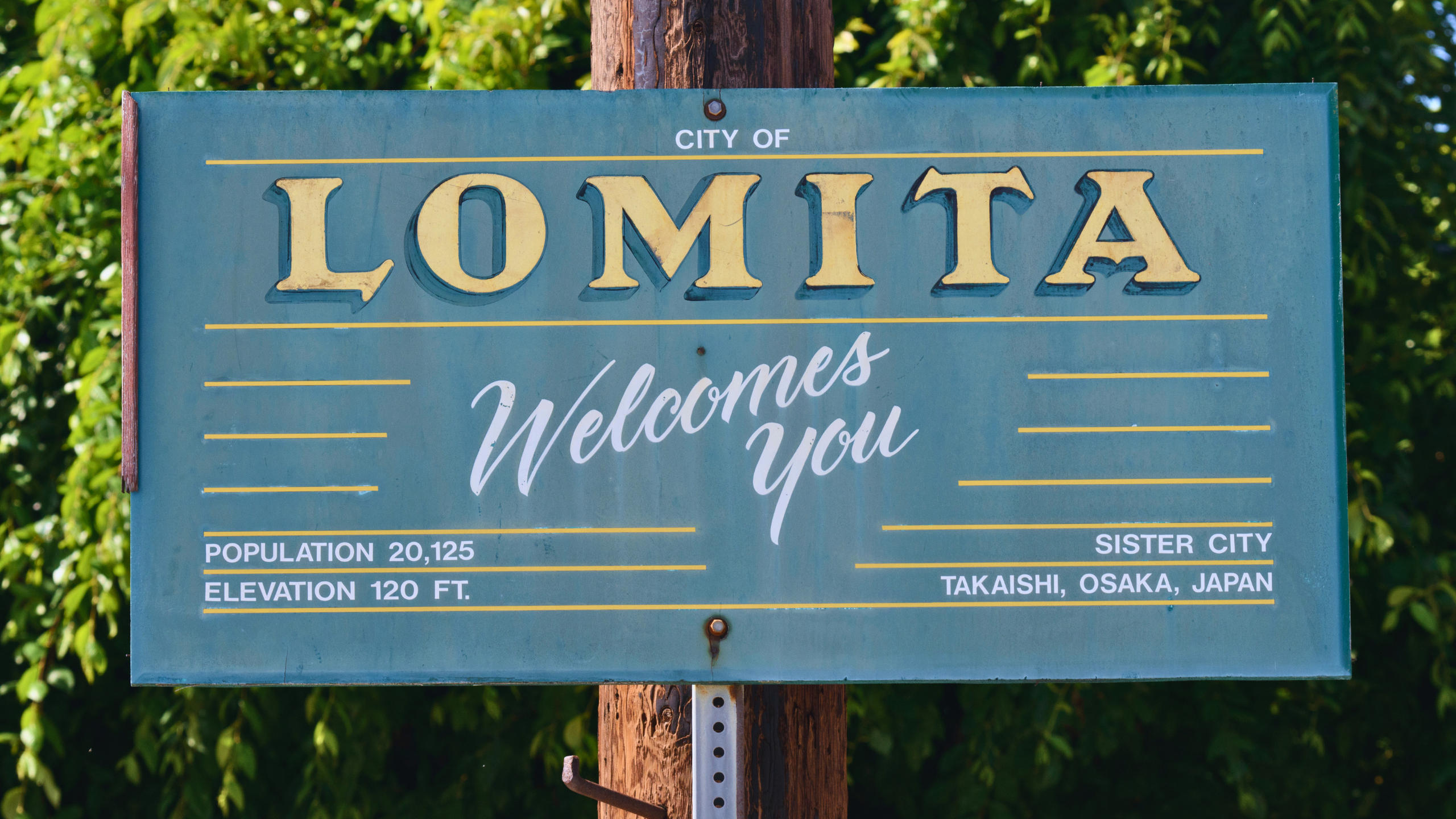 City of Lomita welcome sign surrounded by greenery